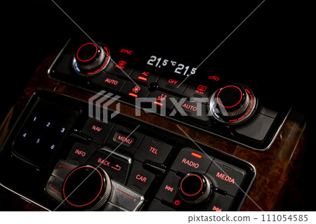 Interior of modern luxury car. Details of automatic transmission gear shift, multimedia control system, car control panel, Air Vent Red emergency button and dashboard inside. Prestige sport automobile Interior of modern luxury car. Details of automatic transmission gear shift, multimedia control system, car control panel, Air Vent Red emergency button and dashboard inside. Prestige sport automobile 111054585