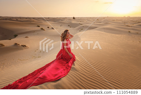 Woman in sands dunes of desert at sunset 111054889