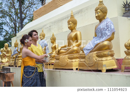 Songkran Day, young Thai people wear Thai costumes to bathe Buddha statues and play on Songkran Day. Songkran Day, young Thai people wear Thai costumes to bathe Buddha statues and play on Songkran Day. 111054923