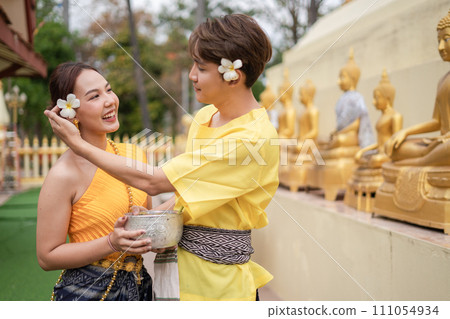 On Songkran Day, young Thai people wear Thai costumes to bathe Buddha statues and play on Songkran Day. 111054934