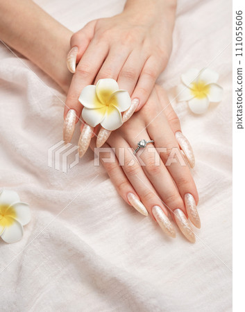 Hand of a young woman with white pearl  manicure 111055606