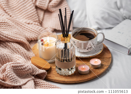 Bamboo sticks in bottle with scented candles and cup of coffee 111055613