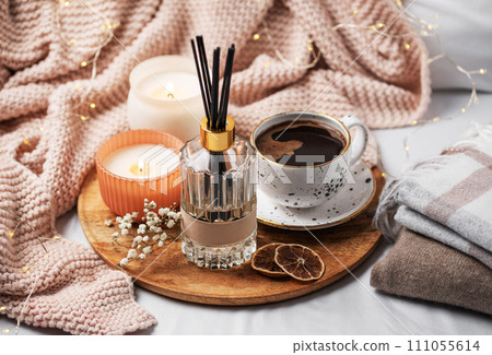 Bamboo sticks in bottle with scented candles and cup of coffee 111055614