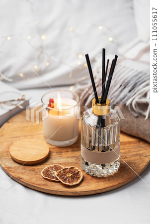 Home fragrance in glass bottle and bamboo sticks with scented candle,  paper book. 111055617