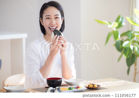 Breakfast: Woman eating rice balls 111056177