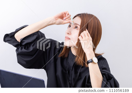 Woman applying eye drops 111056189