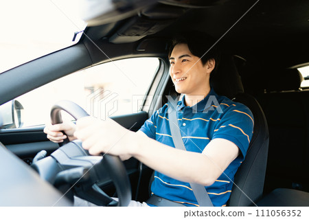 A young man in short sleeves driving 111056352