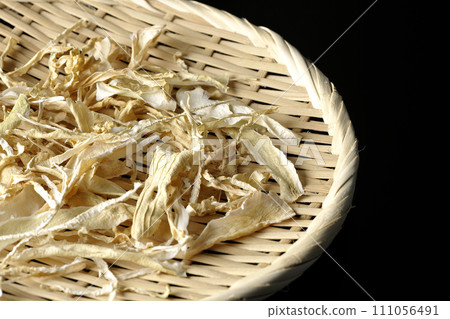 Dried radish skin photographed against a black background 111056491