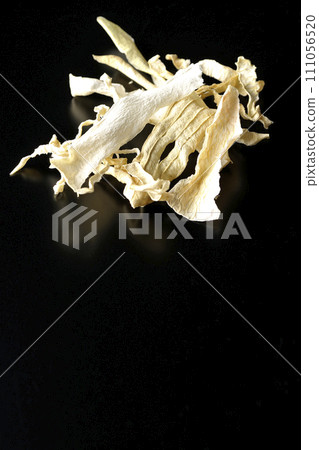 Dried radish skin photographed against a black background 111056520