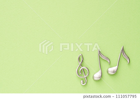 音樂影像:高音譜號和八分音符物件放置在黃綠色紙上 音樂影像:高音譜號和八分音符物件放置在黃綠色紙上 111057795