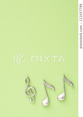 Music image: Treble clef and eighth note objects placed on yellow-green paper 111057799