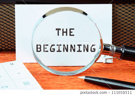 The beginning text written on a white card through a magnifying glass The beginning text written on a white card through a magnifying glass 111058511