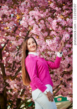 Woman allergic enjoying after treatment from seasonal allergy at spring. Portrait of happy beautiful woman smiling in front of blooming sakura tree at springtime. Spring allergy concept. Woman allergic enjoying after treatment from seasonal allergy at spring. Portrait of happy beautiful woman smiling in front of blooming sakura tree at springtime. Spring allergy concept. 111058597