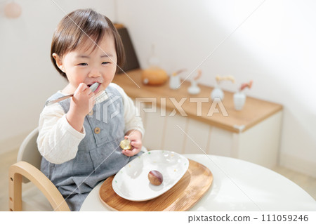 1 year old child eating chestnuts, snack predation 1 year old child eating chestnuts, snack predation 111059246