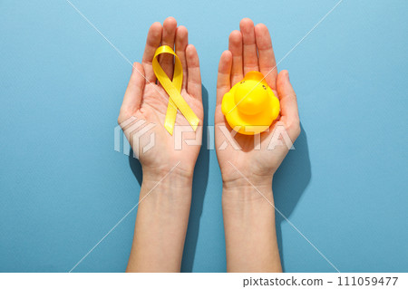 A yellow toy duck with a yellow ribbon 111059477