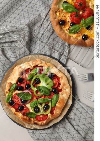 Freshly baked vegetable galettes on a metal tray Freshly baked vegetable galettes on a metal tray 111059544