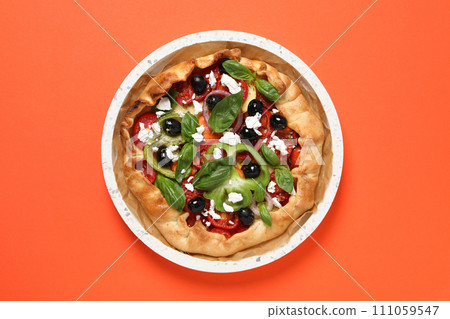 Freshly baked vegetable galettes in a bowl on an orange background 111059547