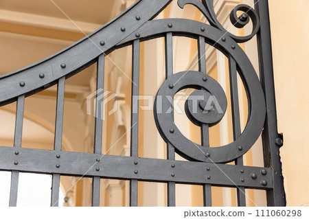 Vintage black forged gate details, close-up photo with selective focus Vintage black forged gate details, close-up photo with selective focus 111060298
