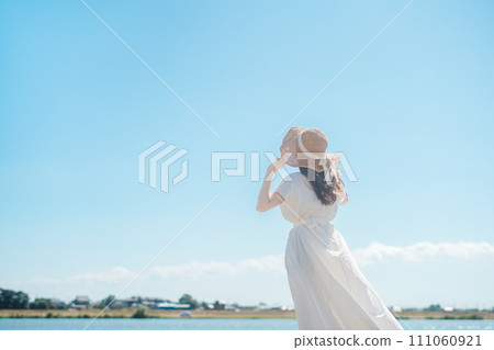 藍天下，身穿白裙、頭戴草帽的女子眺望遠方 111060921