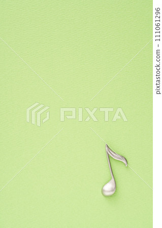 Music image: Eighth note object placed on yellow-green paper Music image: Eighth note object placed on yellow-green paper 111061296