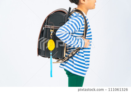 Elementary school student with security buzzer attached to school bag 111061326