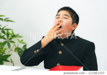 A male student wearing a school uniform yawns 111061337