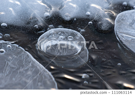 Close-up of an ice bubble on a frozen lake. Lake Kussharo in Hokkaido. 111063114