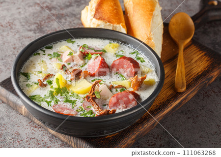 Zalewajka is a delicious traditional Polish sour rye soup with vegetables, sausage and dried mushrooms closeup on the plate. Horizontal Zalewajka is a delicious traditional Polish sour rye soup with vegetables, sausage and dried mushrooms closeup on the plate. Horizontal 111063268