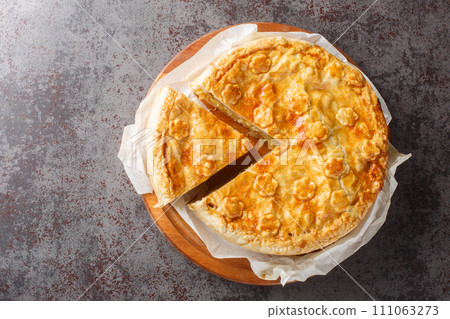 Cholera, leek, potato, apple and cheese pie close-up on a wooden board on the table. Horizontal top view Cholera, leek, potato, apple and cheese pie close-up on a wooden board on the table. Horizontal top view 111063273