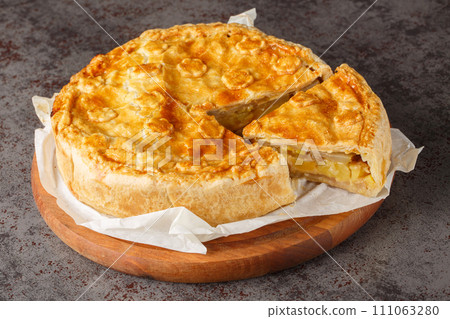 Switzerland food Walliser Cholera cake with potato, leek , apple, cheese closeup on the wooden board. Horizontal 111063280