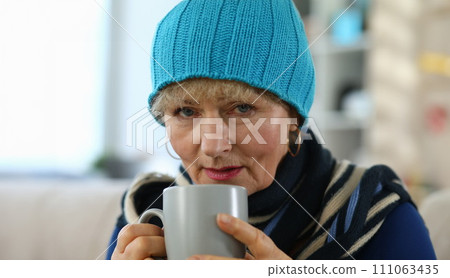 Elderly woman feels sick and drinks tea at home 111063435