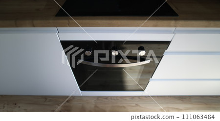 Close-up steel oven built into kitchen surface 111063484
