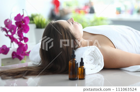 Girl lying at home under towel after massage 111063524