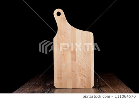 New wooden cutting board on a dark background. New wooden cutting board on a dark background. 111064570