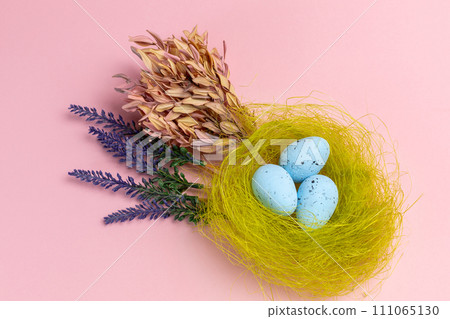 Nest with colored Easter eggs on the pink background. Nest with colored Easter eggs on the pink background. 111065130