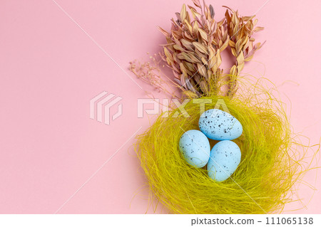 Nest with colored Easter eggs on the pink background. Nest with colored Easter eggs on the pink background. 111065138
