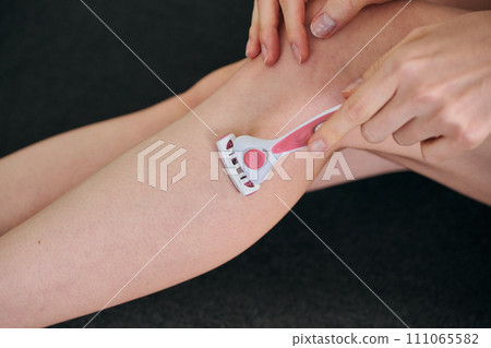 A woman in her 30s shaving her hair with a women's razor A woman in her 30s shaving her hair with a women's razor 111065582