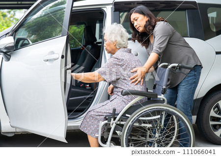 Caregiver help and support asian elderly woman sitting on wheelchair prepare get to her car to travel in holiday. Caregiver help and support asian elderly woman sitting on wheelchair prepare get to her car to travel in holiday. 111066041