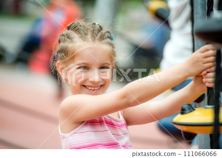 Portrait of Happy smiling little girl playing at the playground and climb the ropes outdoor 111066066