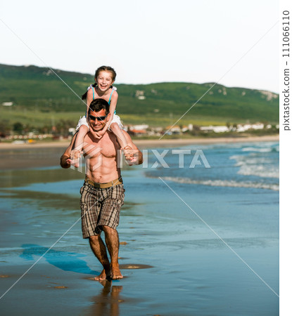 Father holding daughter at shoulders at sea coast and running. Family dad and pretty smiling child kid at beach at summer Father holding daughter at shoulders at sea coast and running. Family dad and pretty smiling child kid at beach at summer 111066110