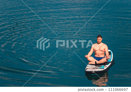 man on paddleboard in the middle of the lake 111066697