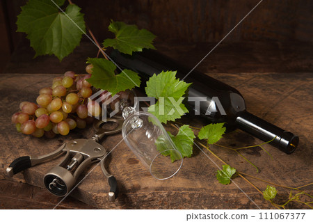 Still life with empty wine glass and grapes on vintage wooden background.. Still life with empty wine glass and grapes on vintage wooden background.. 111067377