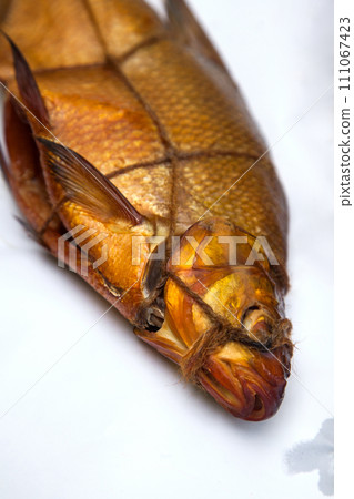 Smoked freshwater common bream fish for home use on white paper.. 111067423
