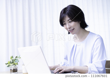 一位年輕女子在陽光明媚的房間裡使用筆記型電腦 一位年輕女子在陽光明媚的房間裡使用筆記型電腦 111067601