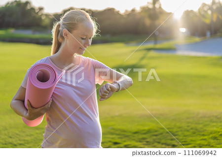 Energetic pregnant woman takes her workout outdoors, using an exercise mat for a refreshing and health-conscious outdoor exercise session Energetic pregnant woman takes her workout outdoors, using an exercise mat for a refreshing and health-conscious outdoor exercise session 111069942