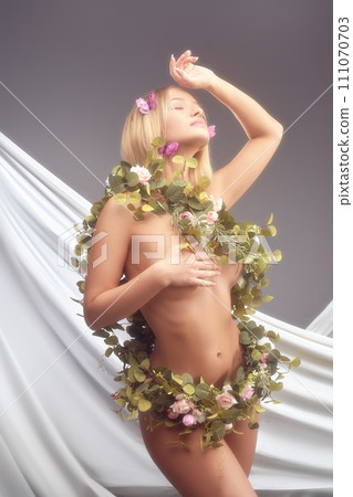 Alluring goddess of flowers covering with liana on her body Alluring goddess of flowers covering with liana on her body 111070703