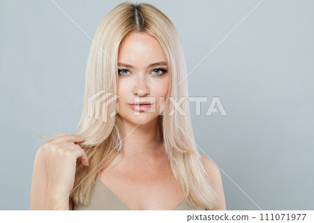 Gorgeous smiling joyfully female model with fair hair looking at camera, being happy. 111071977