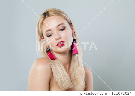Attractive fashion model woman with blonde hair wears big pink color earrings. Fashionable lady Attractive fashion model woman with blonde hair wears big pink color earrings. Fashionable lady 111072024