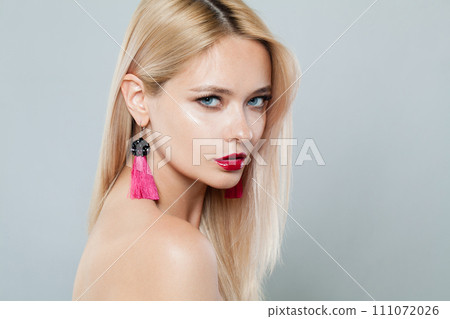 Perfect fashion model woman with blonde hair wears big pink color earrings. Fashionable lady 111072026