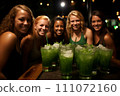 Group of friends joyfully celebrating St. Patricks Day with glasses of green beer in bar 111072160